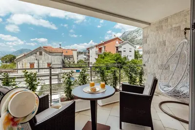 a balcony with a table and chairs and a view at Apartments Dabinovic in Kotor