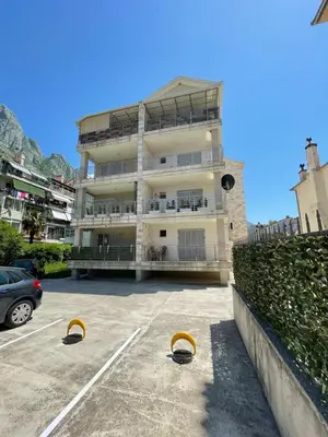a large building with a parking lot in front of it at Apartments Dabinovic in Kotor