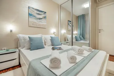 a bedroom with a large white bed with a mirror at Apartments Dabinovic in Kotor