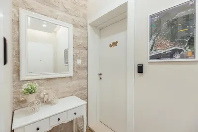 a bathroom with a white sink and a mirror at Apartments Dabinovic in Kotor