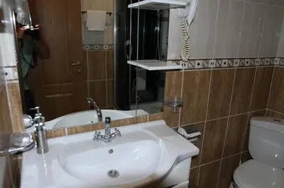 a bathroom with a sink and a toilet and a phone at Apartments Muhar in Sveti Stefan