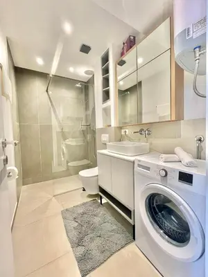 a bathroom with a washing machine and a toilet at Horizon Residences Andjela in Budva