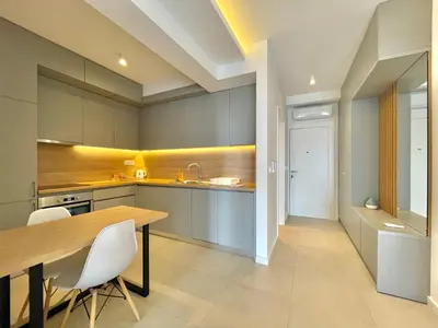 a kitchen with a wooden table and white chairs at Horizon Residences Andjela in Budva