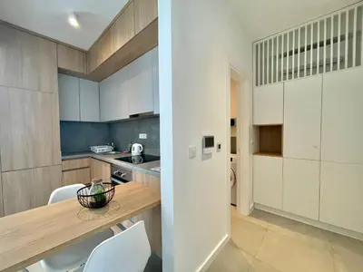 a kitchen with white cabinets and a table and chairs at Horizon Residences Andjela in Budva