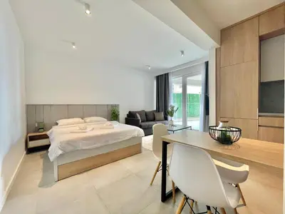 a bedroom with a bed and a table and chairs at Horizon Residences Andjela in Budva