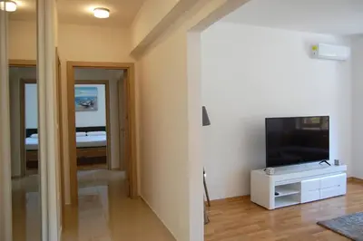 a living room with a television and a room with a bed at Status-M Apartments 85 in Becici