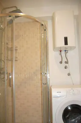 a shower in a bathroom with a washing machine at Status-M Apartments 85 in Becici