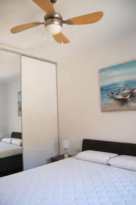a bedroom with a ceiling fan and a bed at Status-M Apartments 85 in Becici