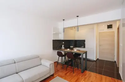 a living room with a white couch and a table at Status-M Apartments 102 in Becici