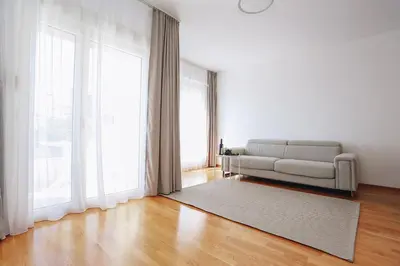 a living room with a couch and a large window at Status-M Apartments 102 in Becici
