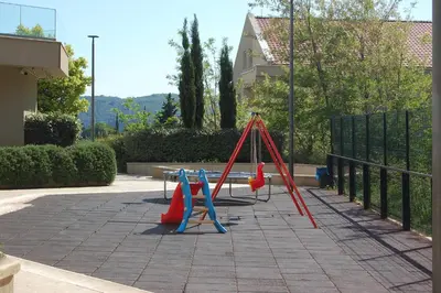 a playground with red and blue swings at Status-M Apartments 102 in Becici