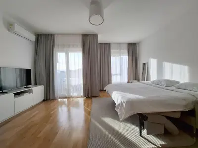 a white bedroom with a bed and a flat screen tv at Status-M Apartments 102 in Becici