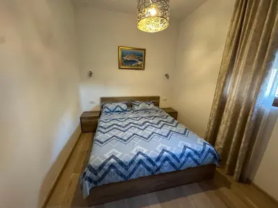 a bedroom with a bed and a chandelier at Engora 2 in Petrovac na Moru