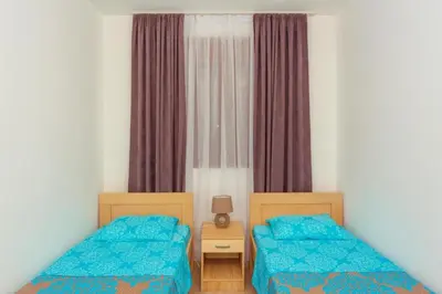 a bedroom with two beds and a window at Engora 2 in Petrovac na Moru