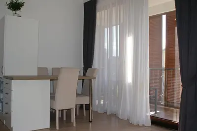 a dining room with a table and chairs and a window at Engora 2 in Petrovac na Moru