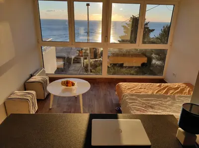a living room with a table and a large window at Apartment A4 in Ulcinj