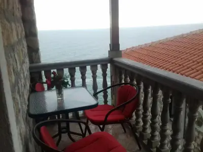 a balcony with a table and chairs and the ocean at Guest house Naser in Ulcinj