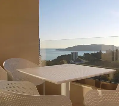 a white table and chairs in front of a window at Status-M apartments 98 in Becici