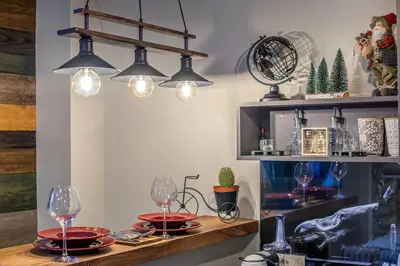 a room with a table with glasses and lights at Apartman_PidžuN in Cetinje