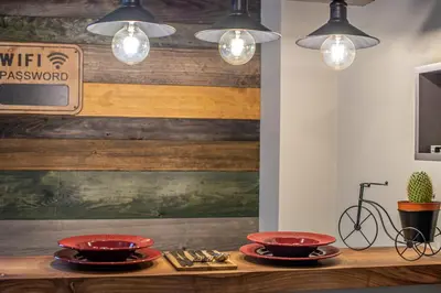 a table with two red bowls on it with lights at Apartman_PidžuN in Cetinje
