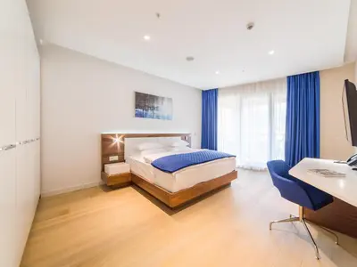 a bedroom with a bed and a desk with a computer at Hotel TQ Plaza in Budva