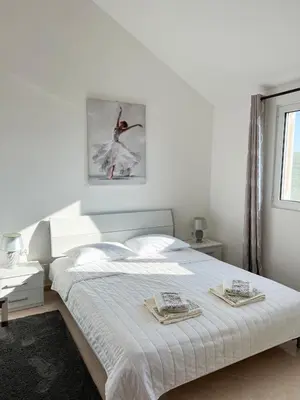 a white bedroom with a bed with two towels on it at Villa Pari Apartment in Kotor