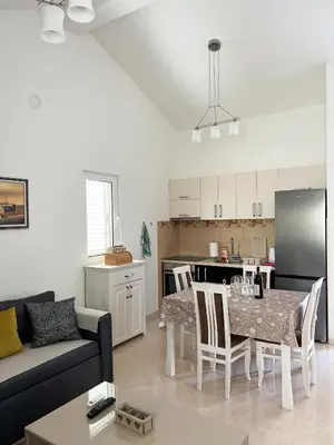 a living room with a table and a kitchen at Villa Pari Apartment in Kotor