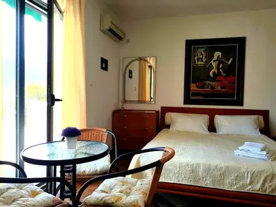 a bedroom with a bed and a table and chairs at Villa Lutovac Budva in Budva