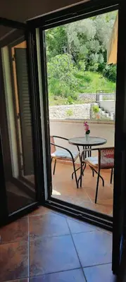 a glass door leading to a patio with a table at Villa Lutovac Budva in Budva