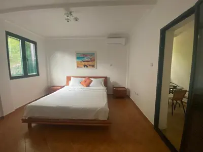 a bedroom with a white bed and a table at Villa Lutovac Budva in Budva