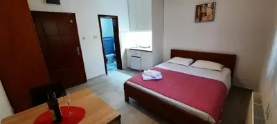 a bedroom with a bed and a table with a bottle of wine at Villa Lutovac Budva in Budva