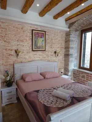 a bedroom with a large bed with pink pillows at Apartaments Charlie Chaplin in Kotor