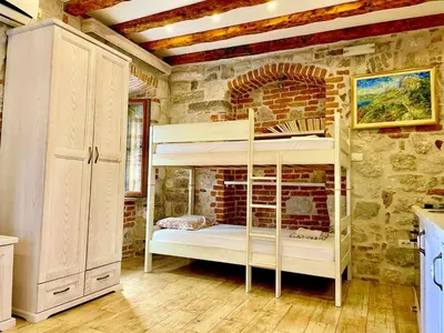 a room with a bunk bed in a brick wall at Apartaments Charlie Chaplin in Kotor