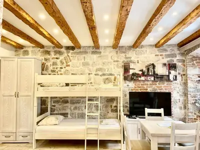 a room with a bunk bed and a table at Apartaments Charlie Chaplin in Kotor