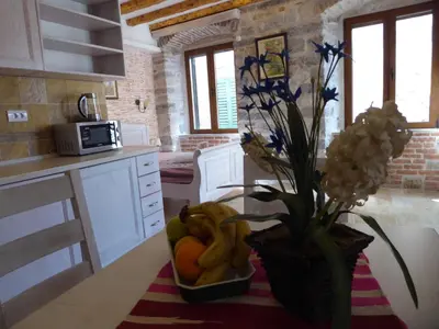 a kitchen with a bowl of fruit and a vase of flowers at Apartaments Charlie Chaplin in Kotor