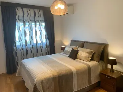 a bedroom with a bed with a blanket and a window at Panorama Bar 2 bedroom in Bar