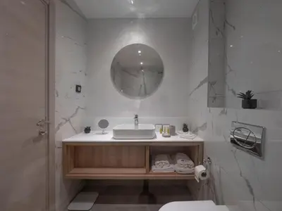a white bathroom with a sink and a mirror at Hotel Idila Budva in Budva