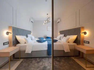 a bedroom with two beds with blue pillows at Hotel Idila Budva in Budva