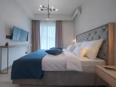 a bedroom with a large bed with pillows on it at Hotel Idila Budva in Budva
