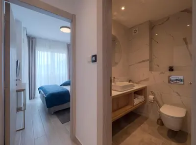 a bathroom with a toilet and a sink and a shower at Hotel Idila Budva in Budva