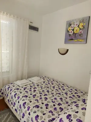 a bedroom with a bed with a floral bedspread at Villa Lyudmila in Utjeha