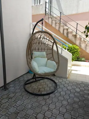 a wicker chair sitting on the side of a building at Villa Lyudmila in Utjeha