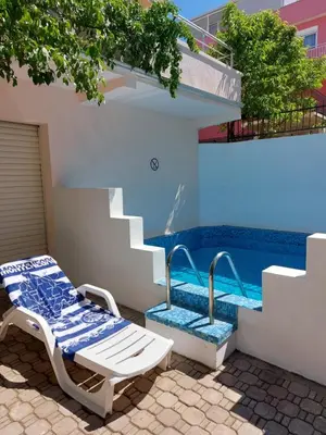 a pool with a bench and stairs next to a house at Villa Lyudmila in Utjeha