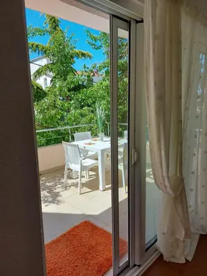 a sliding glass door leading to a patio with a table at Villa Lyudmila in Utjeha
