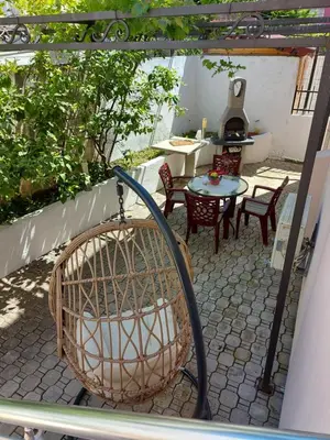 a patio with a bird cage and a table and chairs at Villa Lyudmila in Utjeha