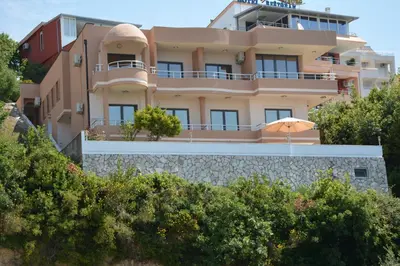 a building with an umbrella in front of it at Guest House Evropa 2 in Ulcinj