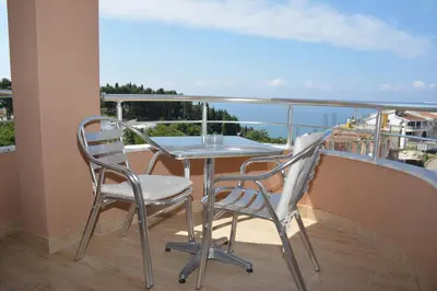a table and chairs on a balcony with a view of the ocean at Guest House Evropa 2 in Ulcinj