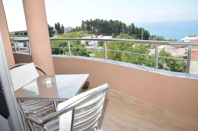 a balcony with a table and chairs and a view of the ocean at Guest House Evropa 2 in Ulcinj