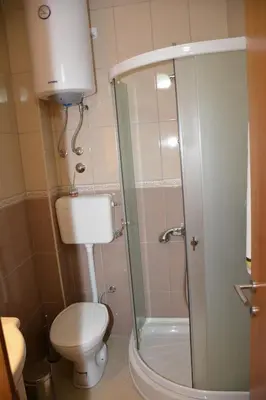 a bathroom with a toilet and a glass shower at Guest House Evropa 2 in Ulcinj