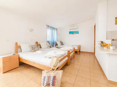 a bedroom with two beds and a bag in it at Apartments Viktorija in Petrovac na Moru